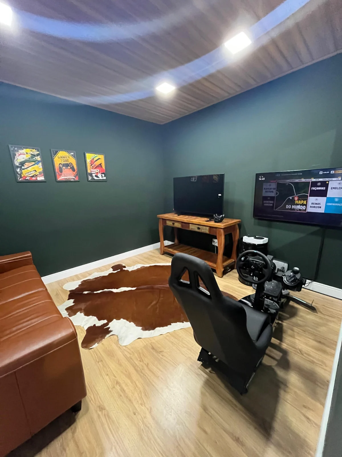 Sala de espera com sofá, TV, Xbox e simulador de corrida