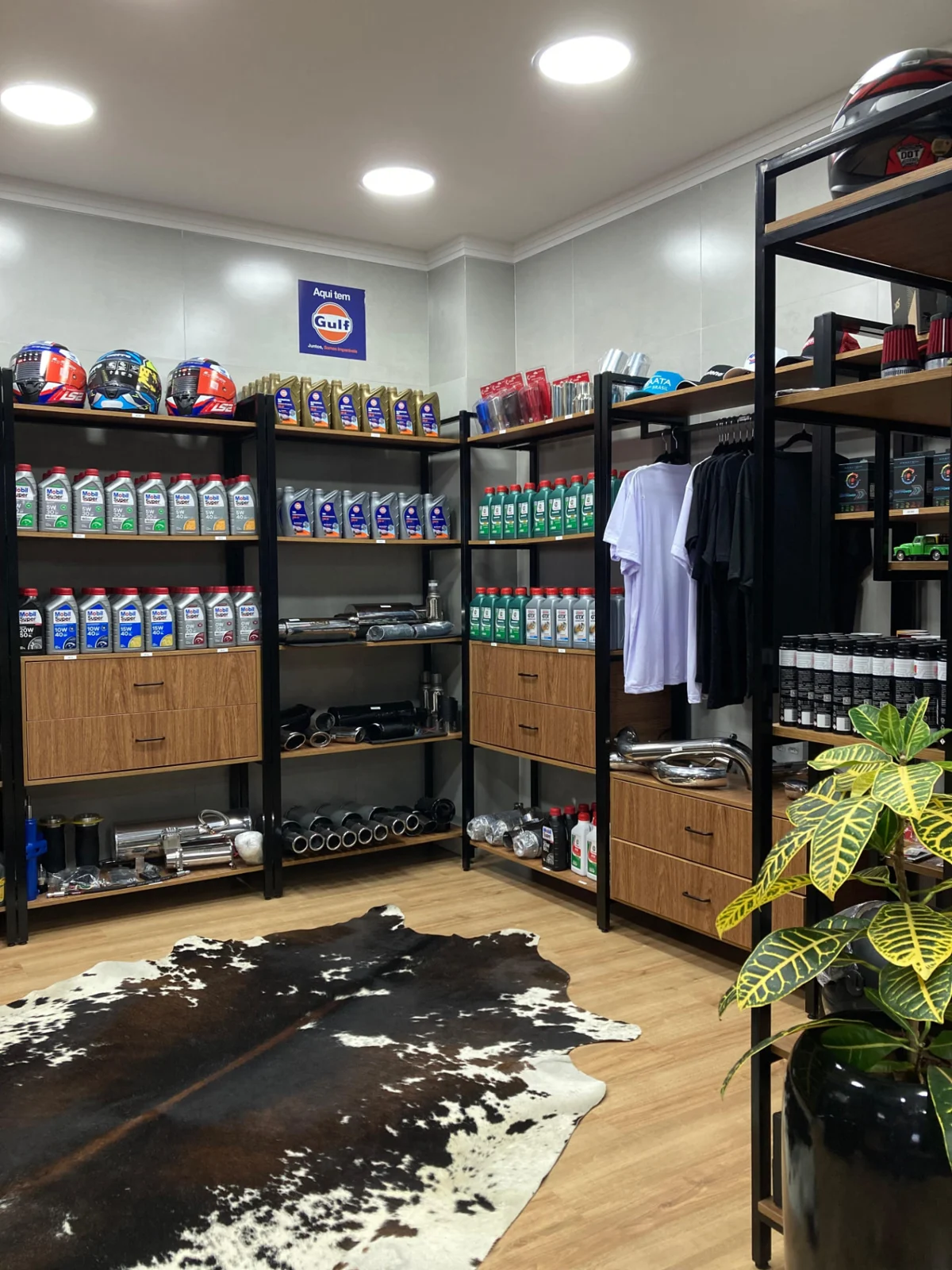 Loja com prateleiras de óleos, escapamentos, capacetes e acessórios